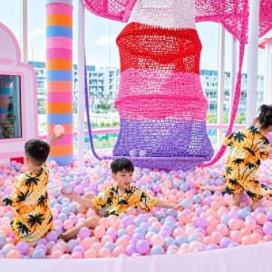 three children playing in a ball pit in a room filled with balls at Toàn Cầu Hotel Quảng Bình in Dong Hoi