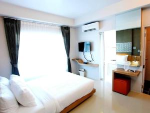 a bedroom with a white bed and a window at Tonkok Hotel in Ban Fang Min