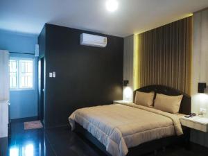 a bedroom with a bed with a black wall at The Nest Hotel in Sathani Phu Khao Lat