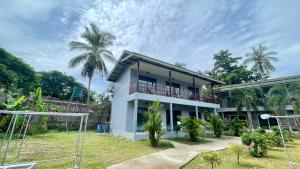 a white house with a balcony and palm trees at Smile Resort Koh Mook in Ko Mook +229 photos