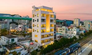 a tall white building in a city at sunset at Paul Mare Pool Villa in Busan