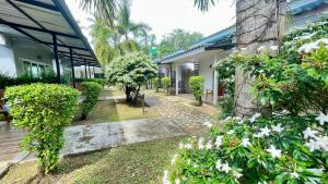 a garden with white flowers and a building at Smile Resort Koh Mook in Ko Mook