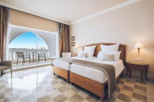 a bedroom with a large bed and a balcony at Iberostar Selection Kantaoui Bay in Port El Kantaoui +167 photos
