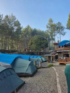 a group of tents sitting on a gravel ground at camp asri in Bukittinggi