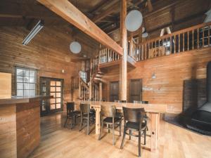 a dining room with wooden walls and a table and chairs at #65 Stella 八ヶ岳姫木平 in Tateshina