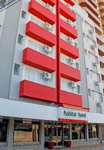 a red and white building with a hotel at Habitat Hotel de Leme Ltda in Leme