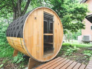 a wooden barrel house sitting on a wooden deck at #65 Stella 八ヶ岳姫木平 in Tateshina