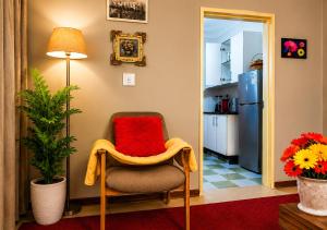 a living room with a chair and a refrigerator at Toby's Apartment in Mbabane +9 photos