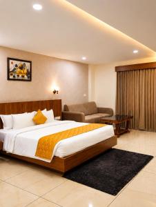 a hotel room with a large bed and a couch at Heaven Suite in Kalpetta