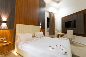 a bedroom with a large white bed and a television at Rose Garden Resort & Spa in Marrakesh +172 photos