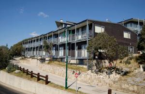 an apartment building on a road with a street sign at Apartment K2 15 AMS Mt Buller in Mount Buller