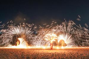 a group of people standing on a beach with fireworks at Mayaana Beach Resort Pattaya - Formerly Golden Tulip Pattaya Beach Resort in North Pattaya +94 photos
