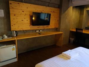 a room with a television on a wooden wall at Southern View Hotel Pattani in Ban Ru Sa Mi Lae