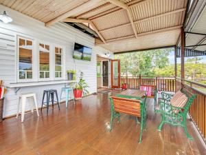a porch with a bench and a table and chairs at Historic Character-filled Jade Cottage in Coalfalls