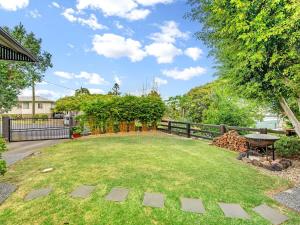 a backyard with a fence and a table and grass at Historic Character-filled Jade Cottage in Coalfalls