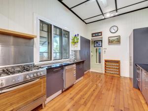 a large kitchen with stainless steel appliances and wooden floors at Historic Character-filled Jade Cottage in Coalfalls
