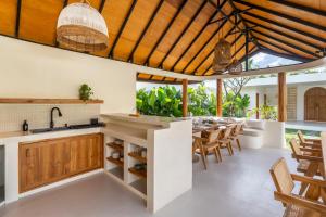 an open kitchen and dining room with a table and chairs at SUMA Bali in Uluwatu
