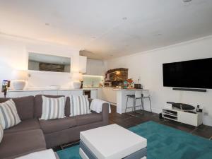 a living room with a couch and a flat screen tv at Rock House in Tintagel