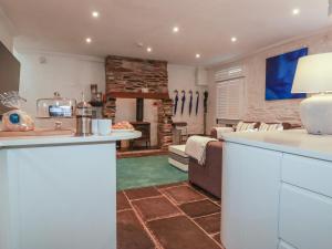 a kitchen and living room with a stone fireplace at Rock House in Tintagel +17 photos
