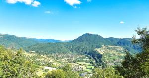a view of a valley with a mountain in the background at Glamping en Tente Yourte in Ispagnac
