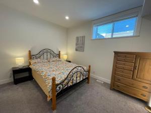a bedroom with a bed and a dresser and a window at Sea view villa independent access in Nanaimo +5 photos