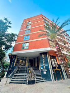 a building with a palm tree in front of it at Verssailles Al Manar Hotel in Cairo