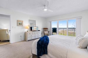 a bedroom with a bed and a television and a balcony at Boardwalk 201 in Cocoa Beach +40 photos