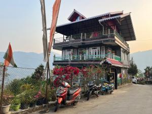 a building with motorcycles parked in front of it at Ningma Lamu Homestay in Mangpu