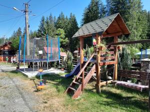 a playground with a slide and a play structure at Cabana Dory și Dan in Arieşeni