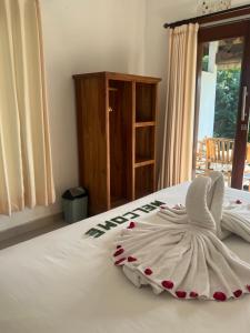 a white bed with a towel on top of it at D'Janu Homestay in Sidemen +15 photos