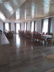 a dining room with tables and chairs and windows at Cabana Dory și Dan in Arieşeni