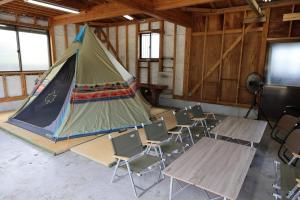 a classroom with tables and chairs and a tent at Dino Base in Mifune