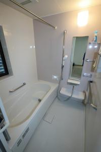 a white bathroom with a tub and a mirror at Dino Base in Mifune +56 photos