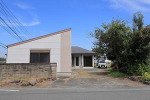 a white building with a car parked in front of it at Dino Base in Mifune