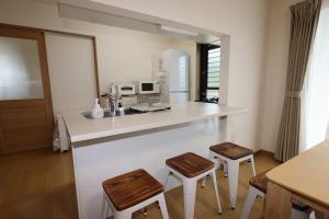a kitchen with a counter with two stools and a counter top at Dino Base in Mifune