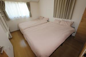 a large bed in a small room with a window at Dino Base in Mifune