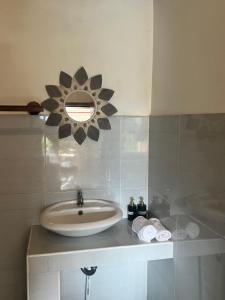 a bathroom with a sink and a mirror on the wall at D'Janu Homestay in Sidemen