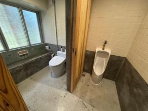 a bathroom with a urinal and a toilet in it at Bunagaya in Ujimi