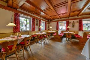 a restaurant with wooden ceilings and tables and chairs at Landhotel zum Metzgerwirt in Bayersoien