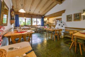 a restaurant with tables and chairs in a room at Landhotel zum Metzgerwirt in Bayersoien +21 photos