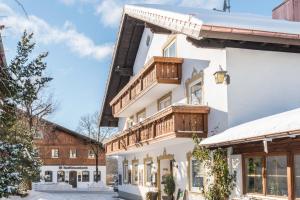 a white building with wooden balconies on it at Landhotel zum Metzgerwirt in Bayersoien