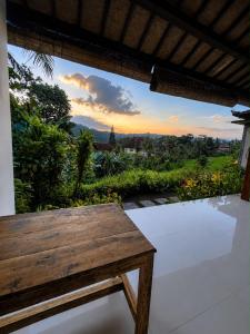 a wooden bench sitting on a patio with a view at D'Janu Homestay in Sidemen