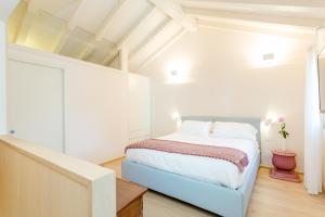 ein weißes Schlafzimmer mit einem Bett in einem Zimmer in der Unterkunft Casa Burano in Burano