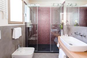 a bathroom with a shower, sink, and toilet at Casa Burano Experience by Venissa in Burano