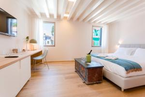 a white bedroom with a bed and a desk at Casa Burano in Burano