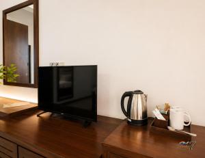 a flat screen tv sitting on top of a wooden dresser at Rainbow Seven Hotel in Negombo +18 photos