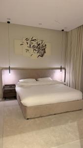 a bedroom with a large bed with white sheets at الربوه سويت in Jeddah