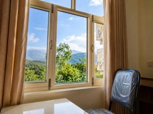 a window with a view of a mountain view at The white range in Baijnāth