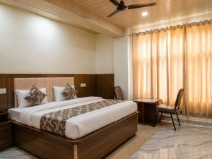 a bedroom with a bed and a desk and a window at The white range in Baijnāth