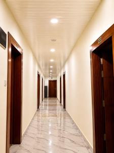 an empty hallway in a building with doors and a tile floor at The white range in Baijnāth